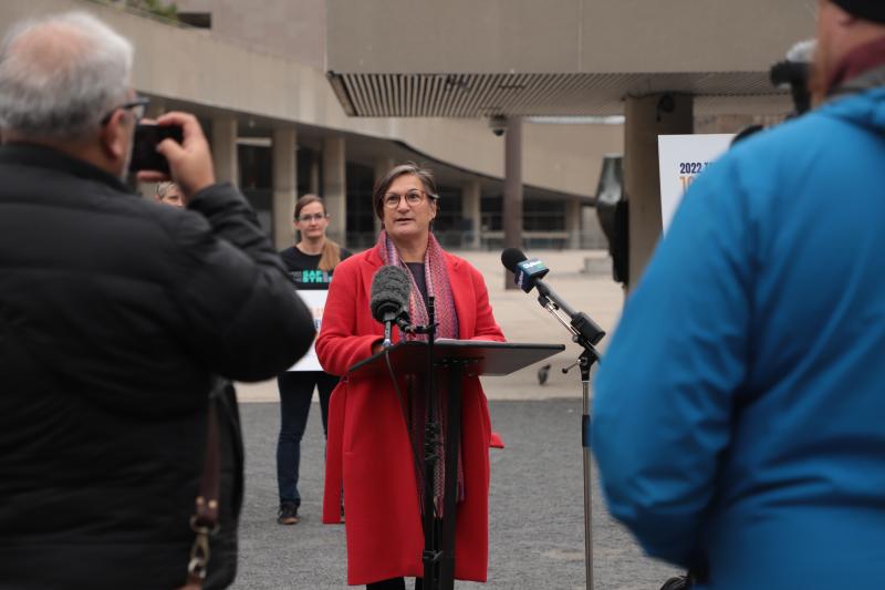 Woman speaking into microphone at podium