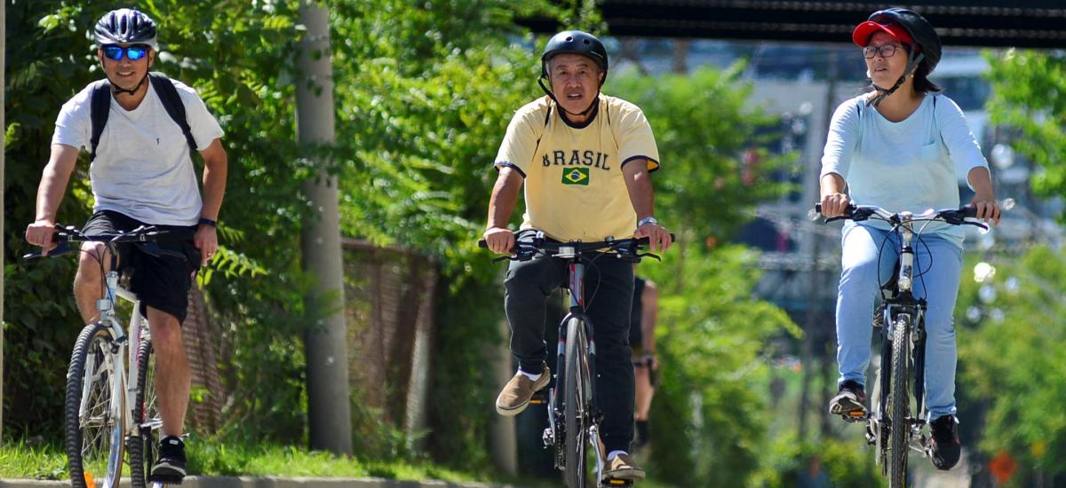 Three people ride bikes