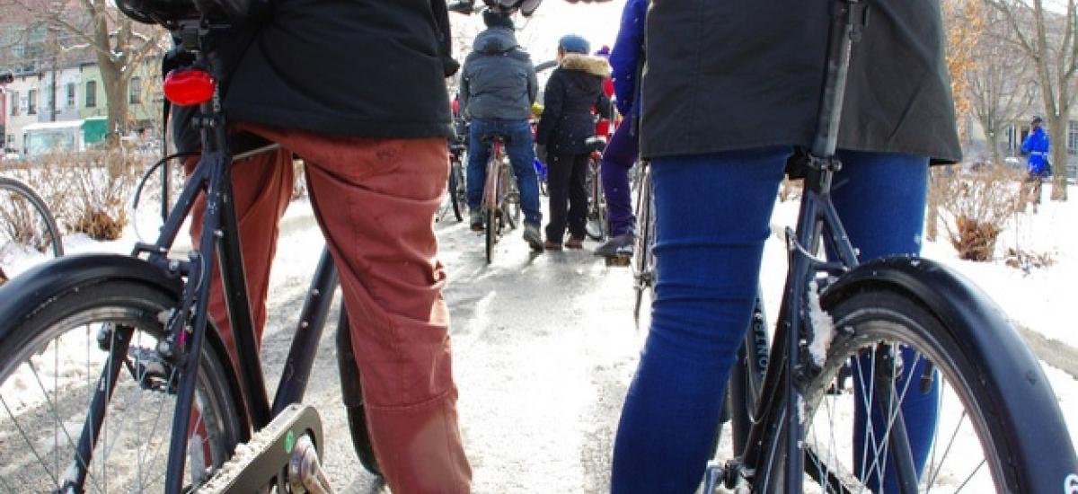 Two people stand with bikes in the snow.