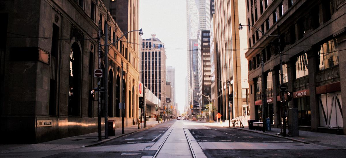 Empty street stretches off into the distance between skyscrapers