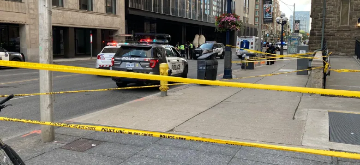 Police tape and vehicles line an intersection