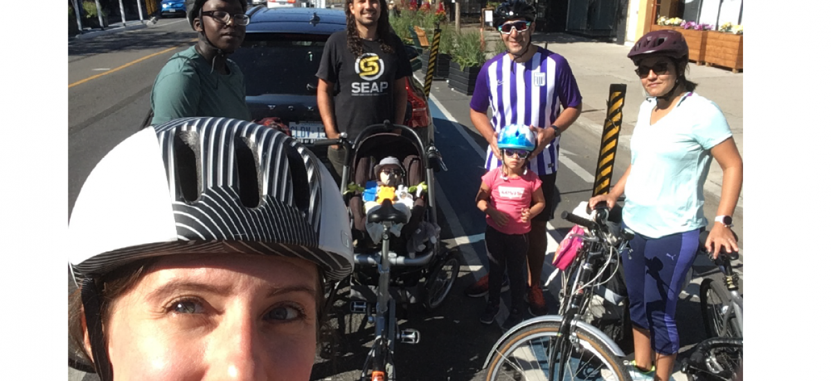 A woman poses with friends and their bikes.