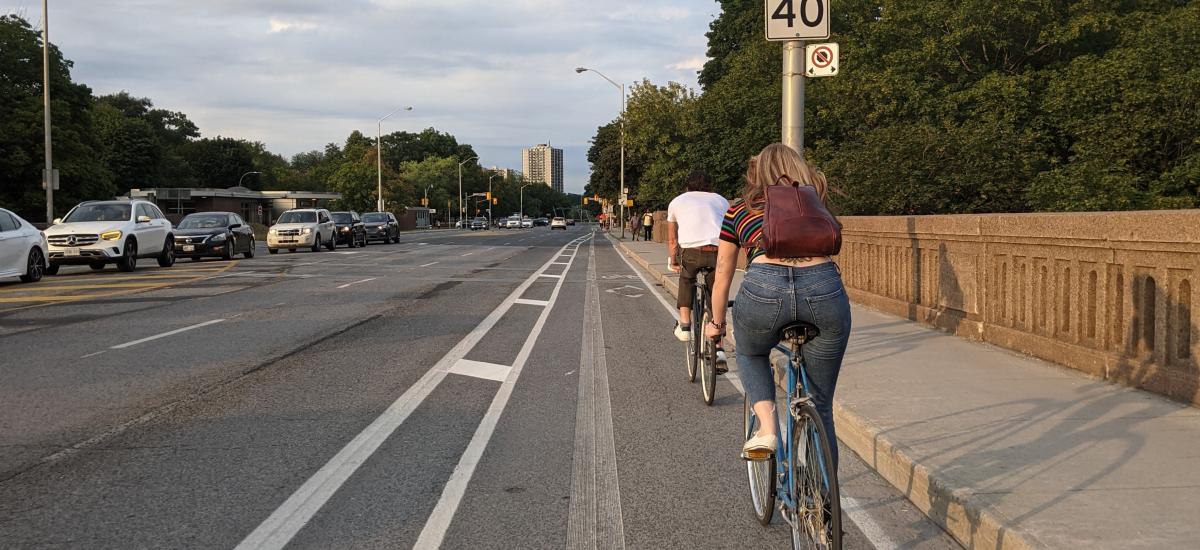 People ride bikes in a buffered bike lane