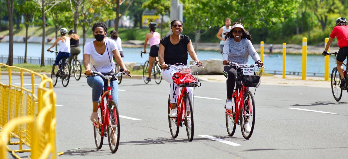 People ride rented bikes and Lake Shore