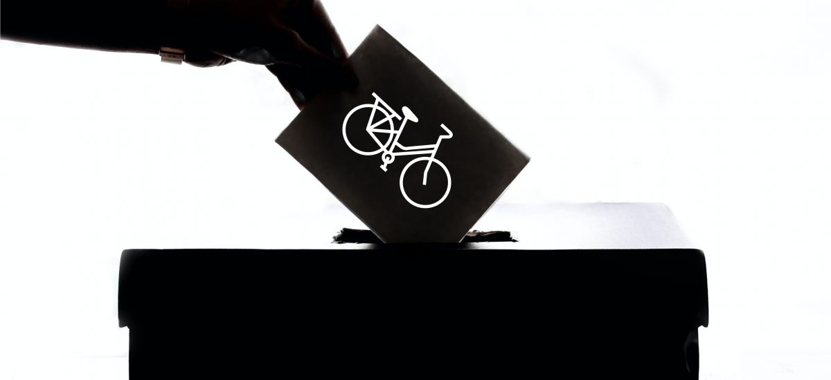 A person puts a ballot with a bike on it in a box