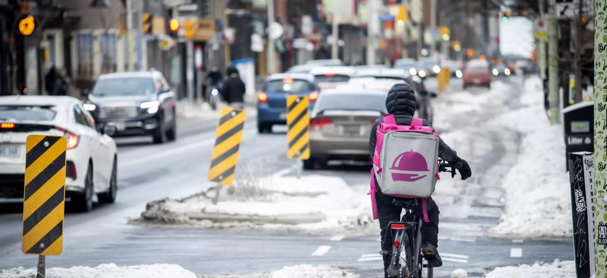 Food courier on an e-bike in a snowy bike lane