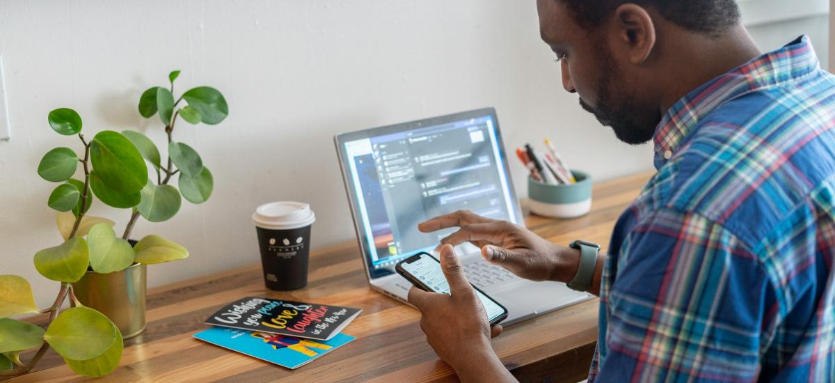 Person using a phone and a laptop