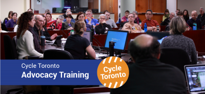 Advocacy Training banner. Photo shows a room full of people listening to a panel of speakers.