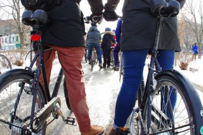 Two people stand with bikes in the snow.