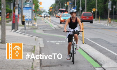 Hashtag Active T O. Person riding a bike in a protected bike lane. They're wearing a tank top and shorts.