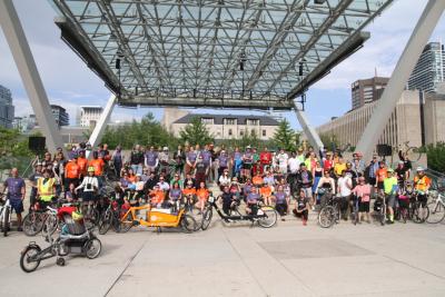 Dozens of people with bikes pose for a group photo in Nathan Phillips Square