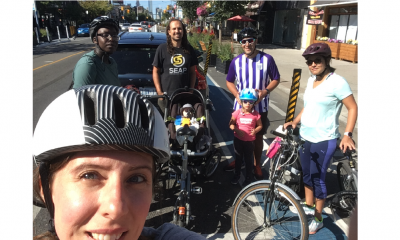 A woman poses with friends and their bikes.