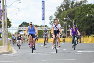 A photo of LakeShore Boulevard West shows that the eastbound lanes have been opened up to people to get around using active transportation. Many people are seen cycling on the road.