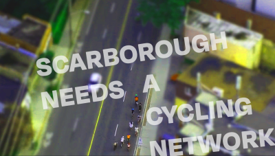 Overhead view of people riding bikes on a wide road. Text reads "Scarborough Needs a Cycling Network"