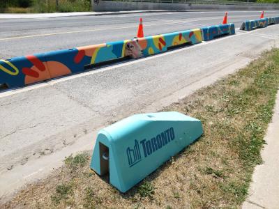 Colourfully painted low concrete walls. One has the Toronto City logo on it in blue.