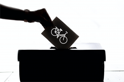 A person puts a ballot with a bike on it in a box