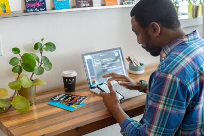 Person using a phone and a laptop
