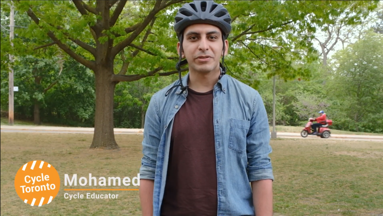 A man wearing a bike helmet in a park. Text reads "Mohammed cycle educator"