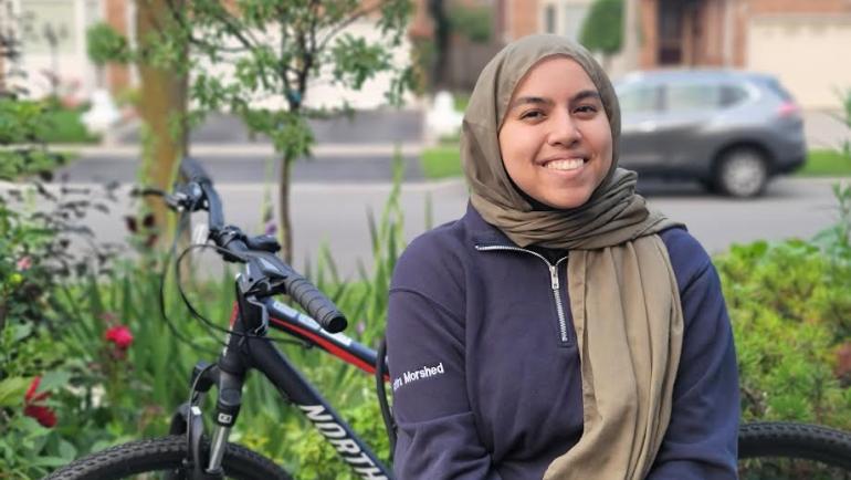 A smiling woman wearing a hijab