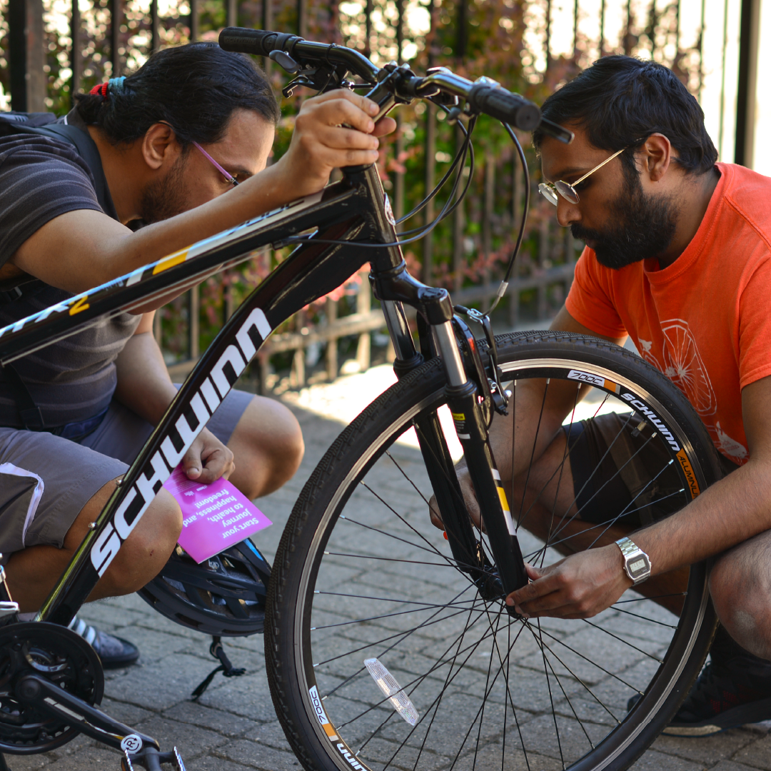 Two people examine a bike.