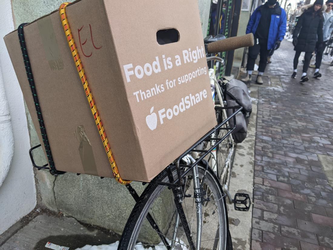 A box on the back of a bike says "Food is a right, thanks for supporting Foodshare"