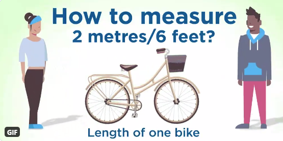 People standing at either end of a bike. How to measure 2 metres? Length of one bike.