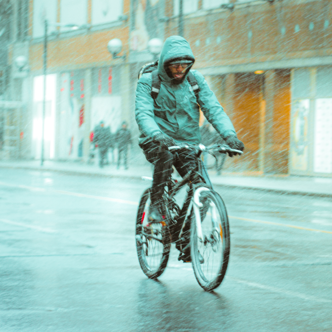 Person rides a bike in the rain.