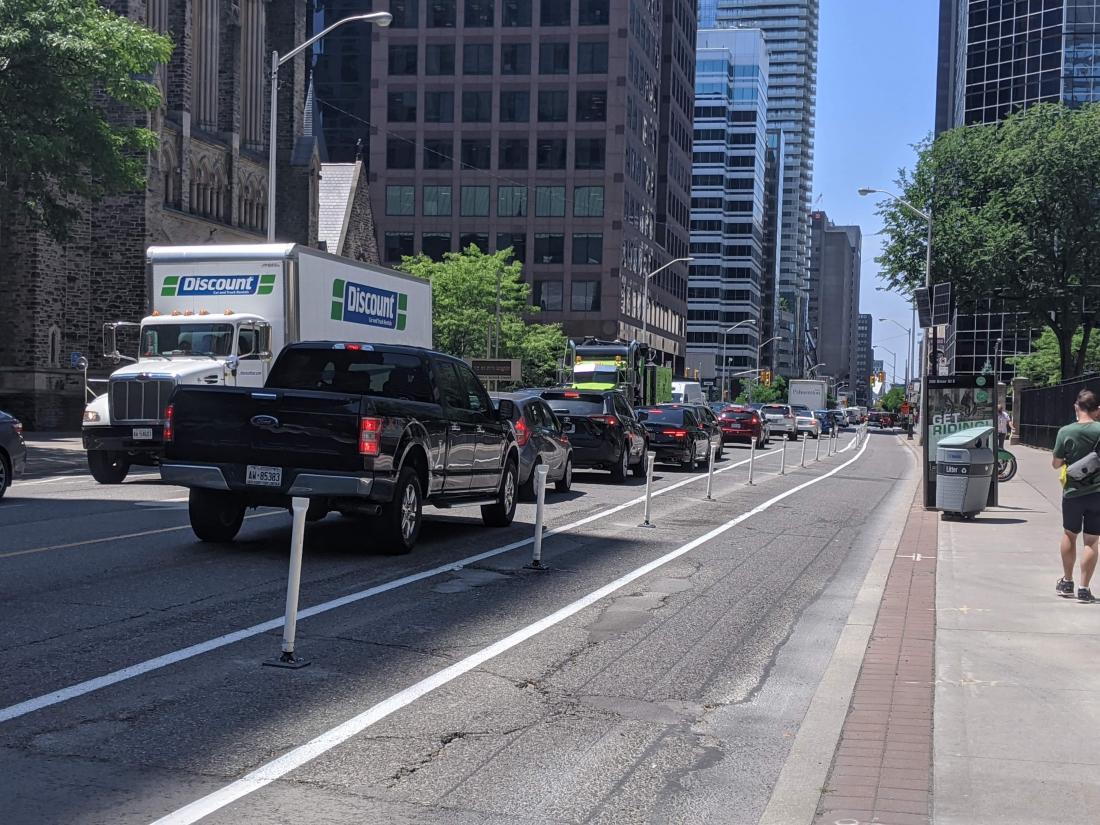 Plastic posts separate a bike lane from car traffic