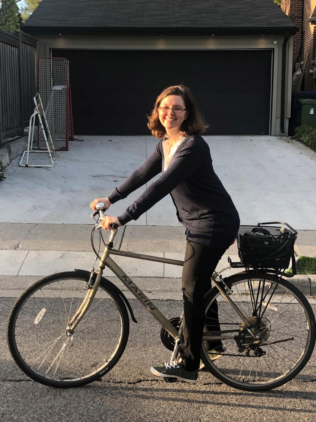 Woman on a bike in front of a driveway