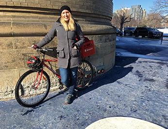 Léa posing with her bike on King's College Circle at U of T