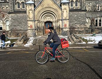 Léa riding her bike on King's College Circle at U of T