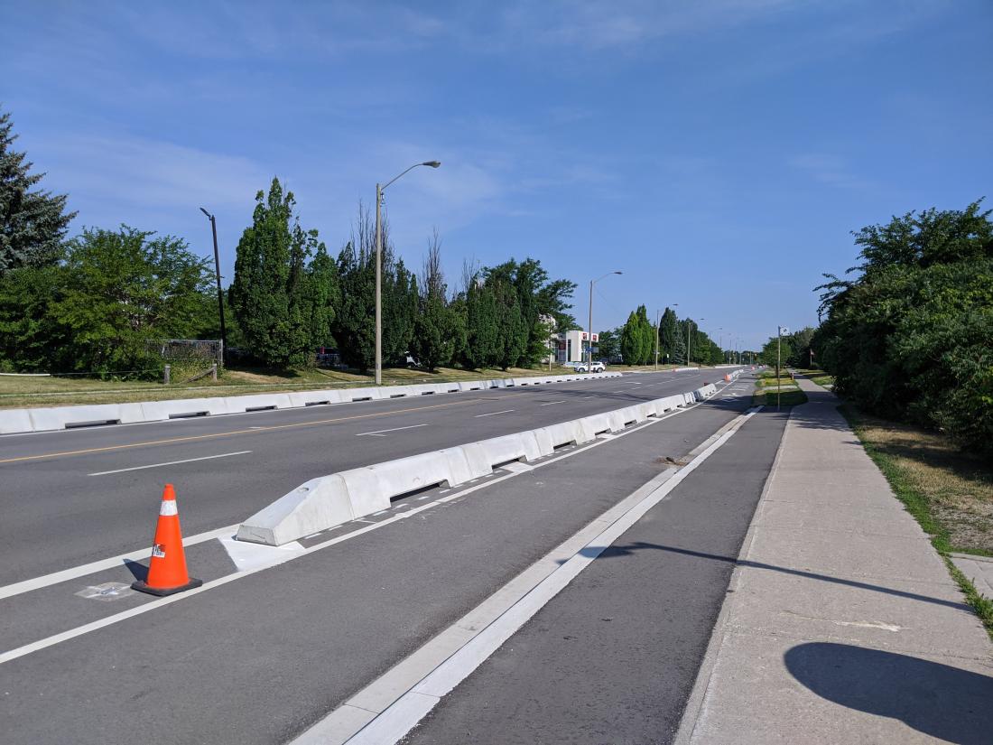 A short concrete wall divides the bike lane from car traffic