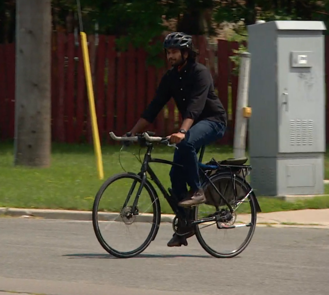 Kevin rides a bike across an intersection