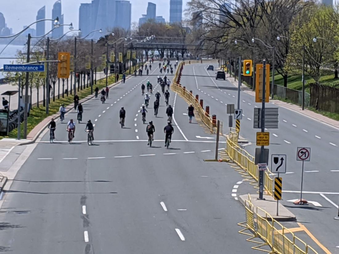 Wide street with many people walking, biking and running on it