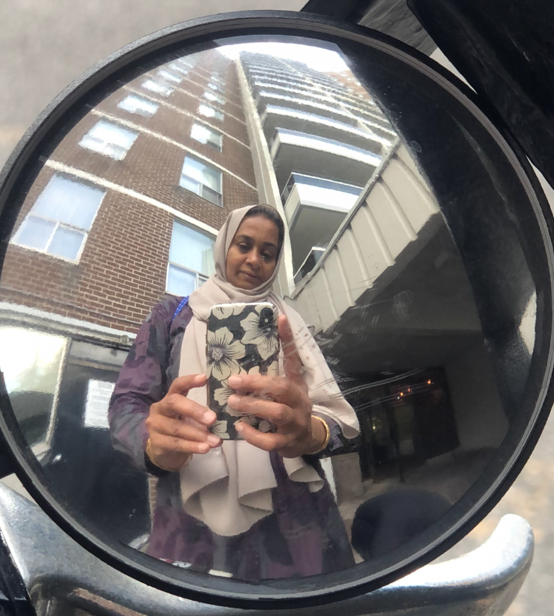 Woman takes a picture of herself in her bikes mirror