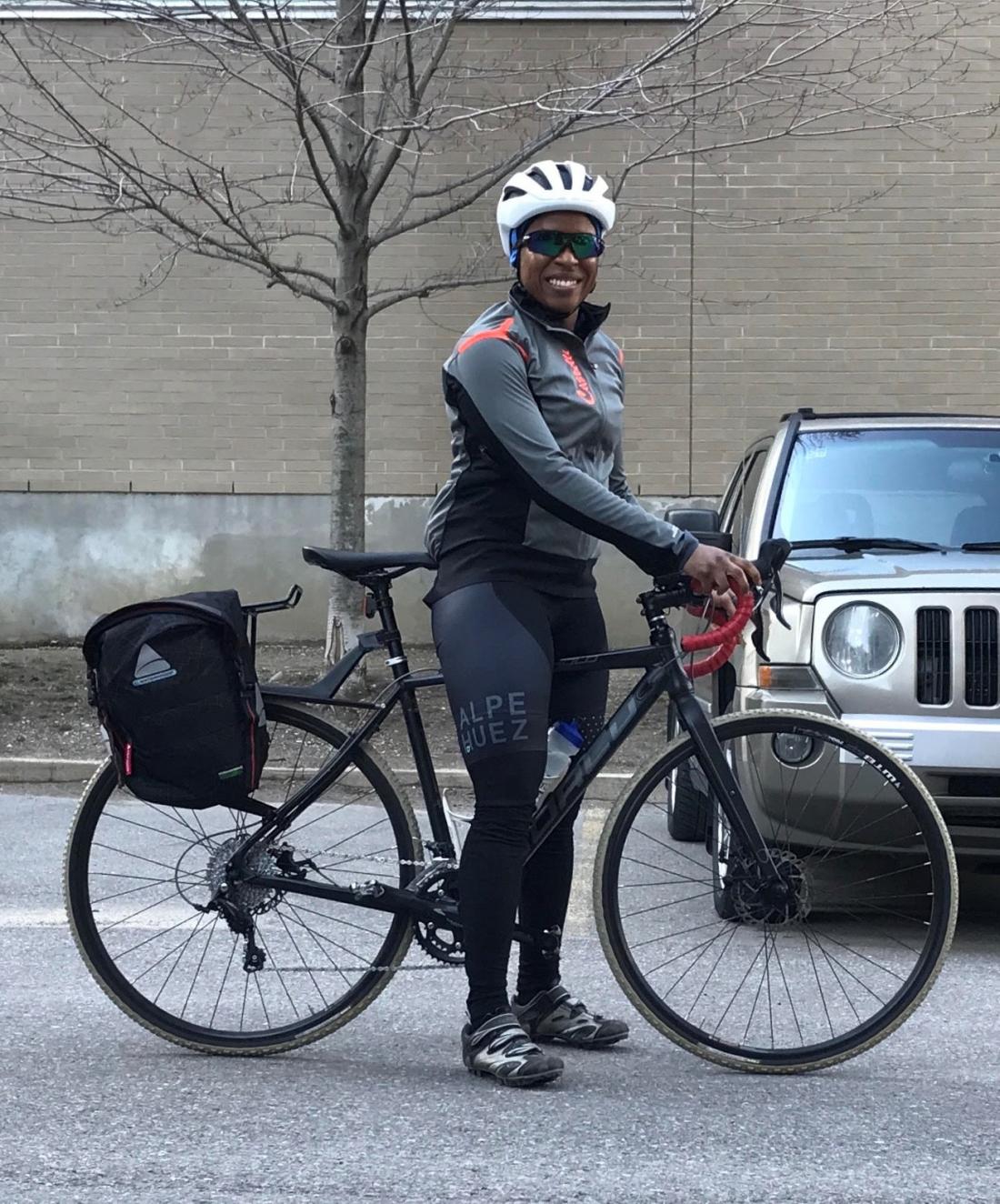 Woman poses with a bike and panniers