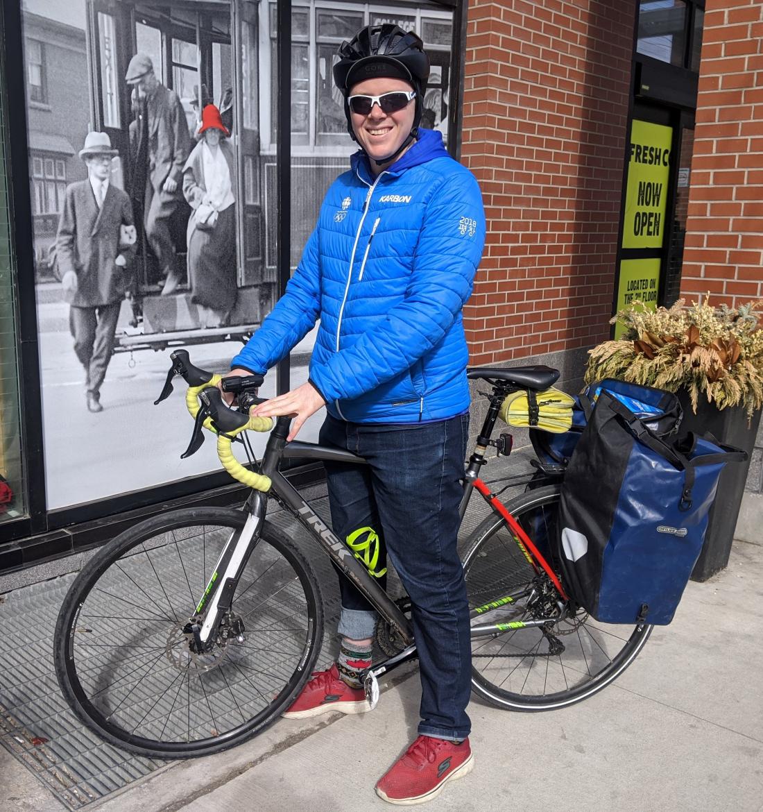 Person in jacket with bike loaded with groceries