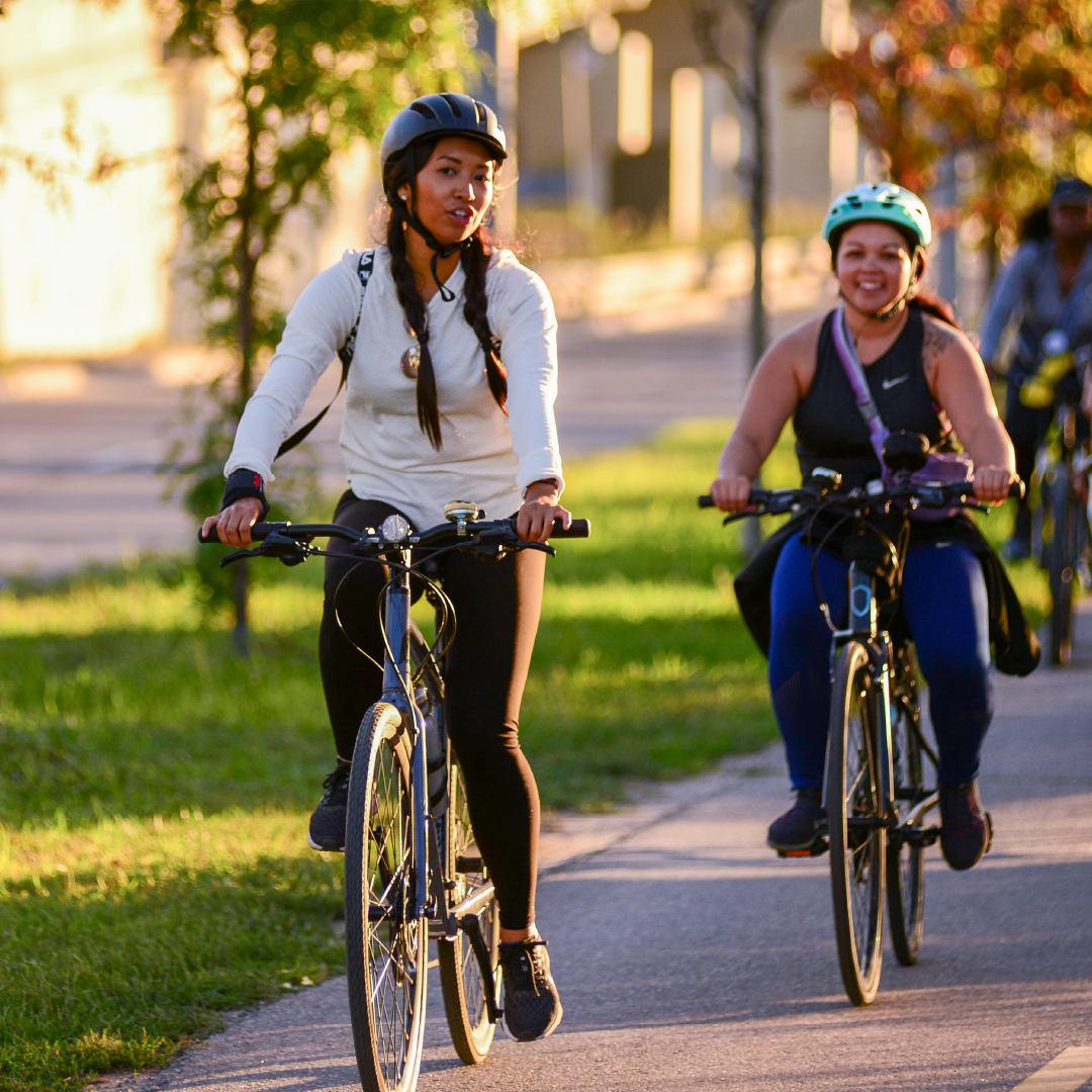 People ride bikes on a path while talking