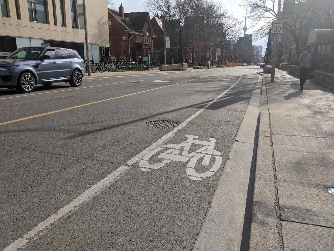 A bike icon is painted on the right side of the road in white. To the left of the icon is a solid white line. The speed limit is 30.