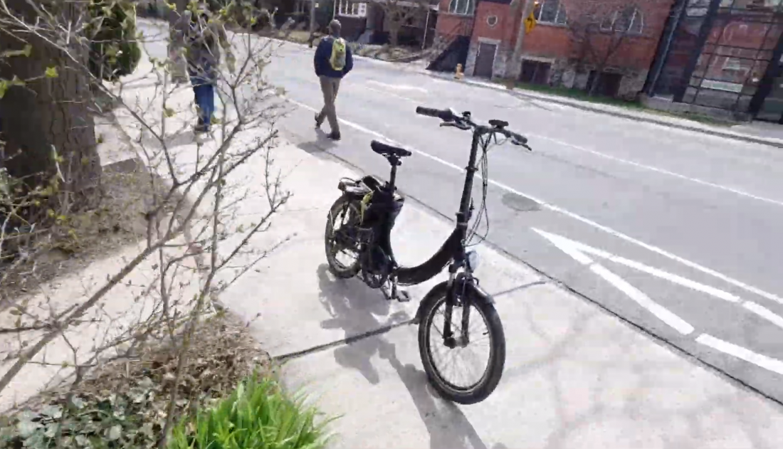 Folding bike parked on sidewalk