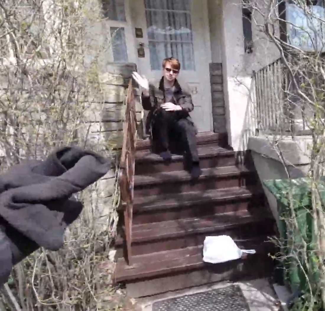 Person sits on porch with bag on steps