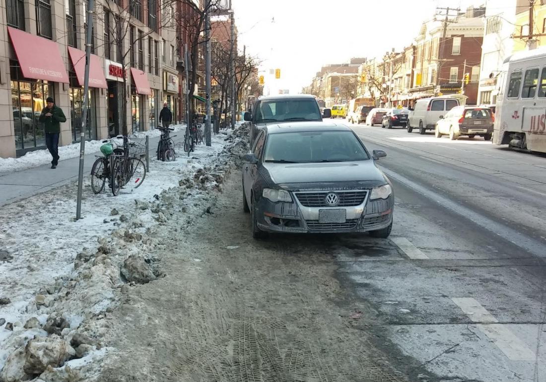 Car and snow spilling into bike lane on College Street