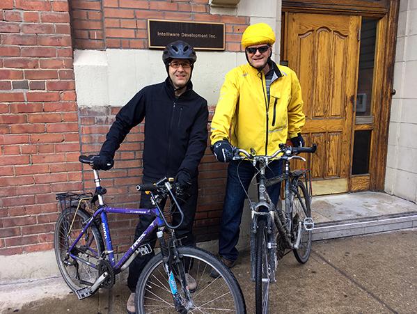 Bruno and Cesar with their bikes in front of their office building