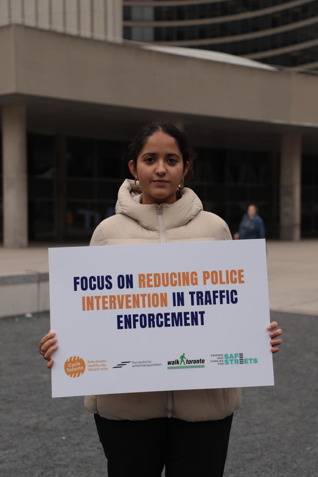 Woman with sign in front of City Hall