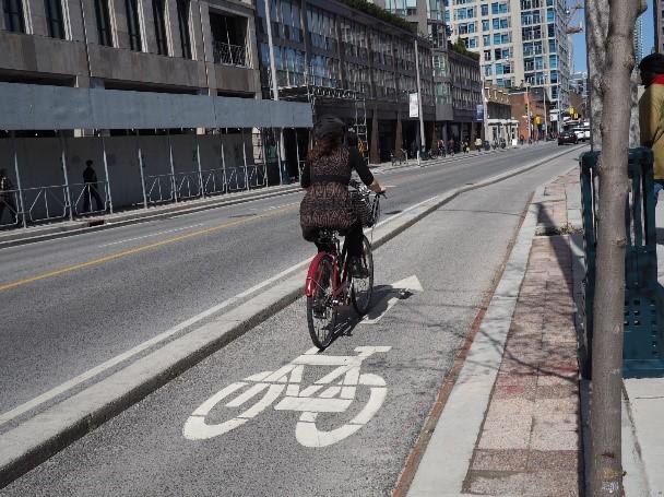 Bike lane at street level on Wellesley Street separated by a concrete curb. Photo courtesy of the City of Toronto.